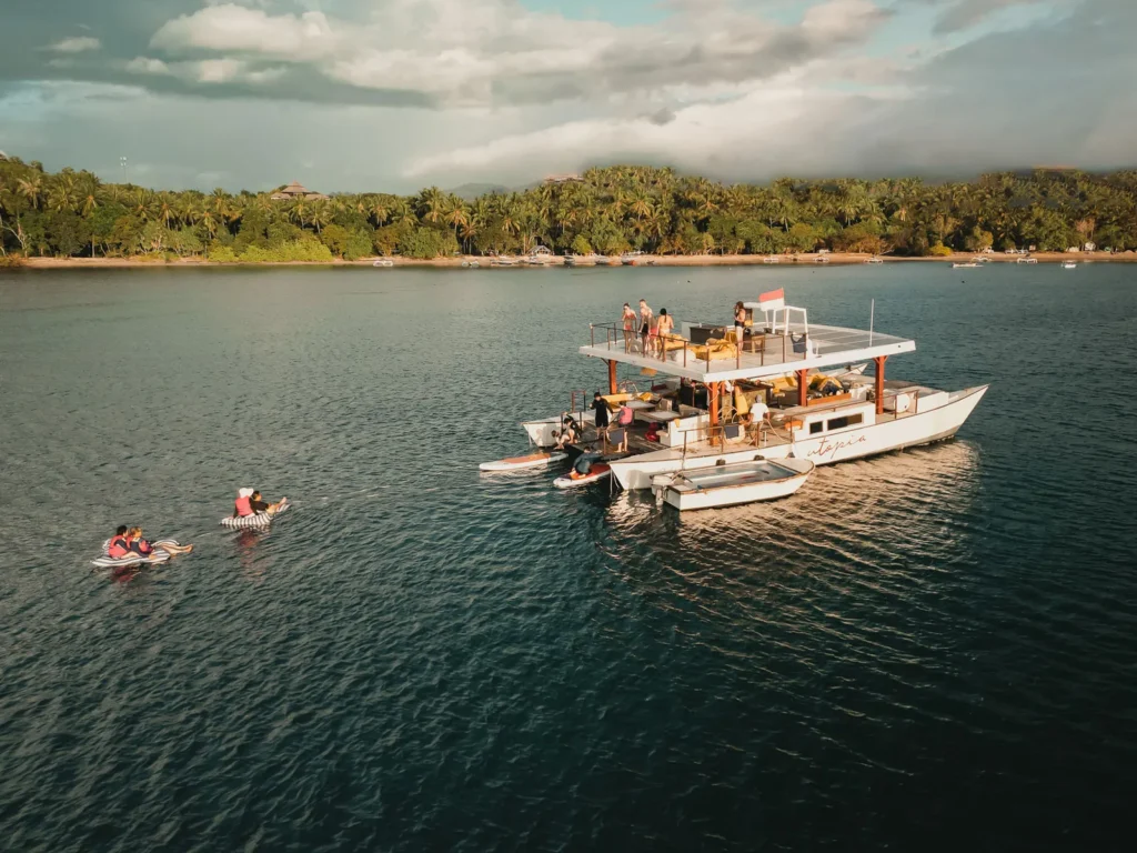 Utopia private catamaran charter floats on the sea just before sunset.